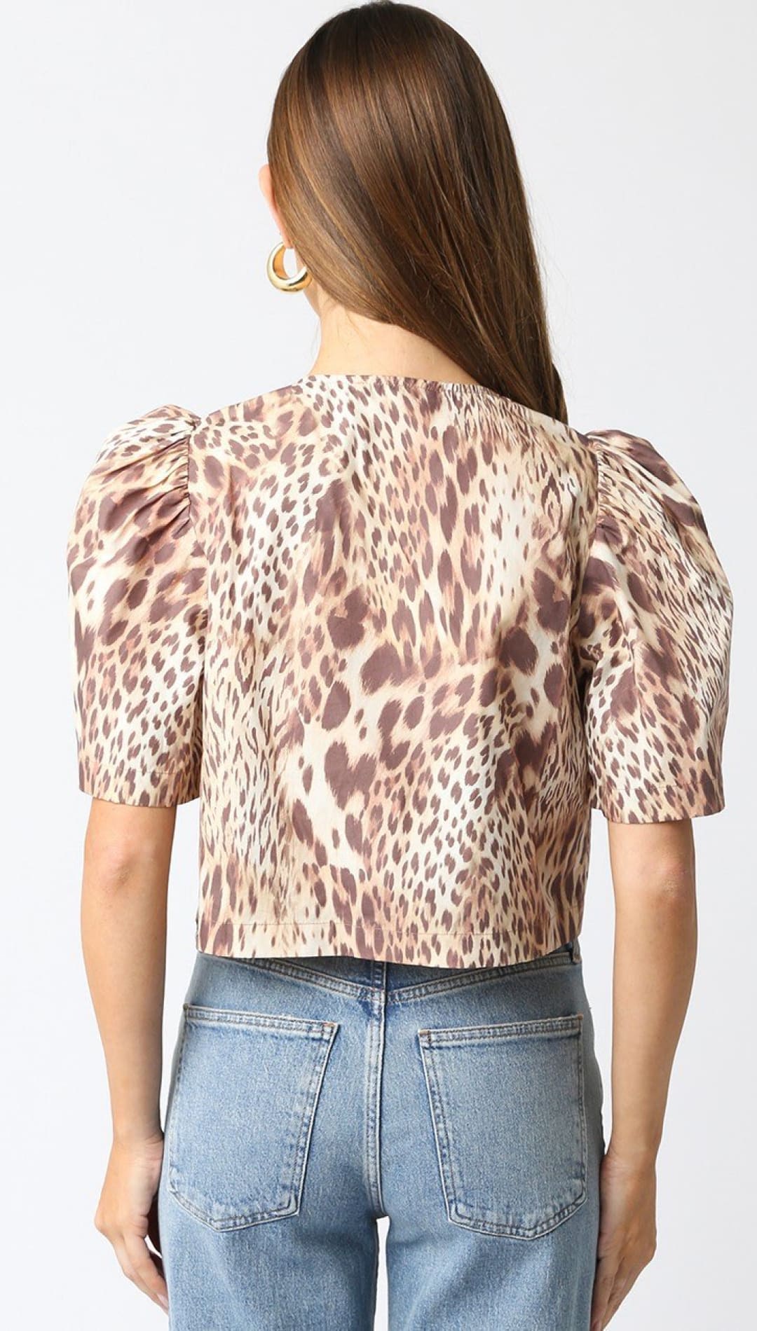 Animal print blouse with puff sleeves paired with blue jeans, shown from behind.