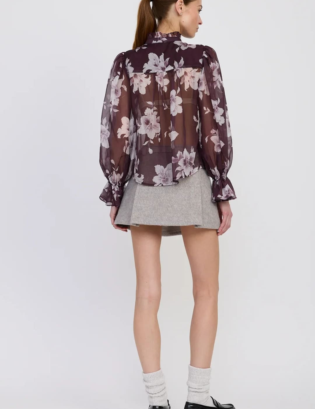 A sheer floral print blouse in shades of purple and cream.