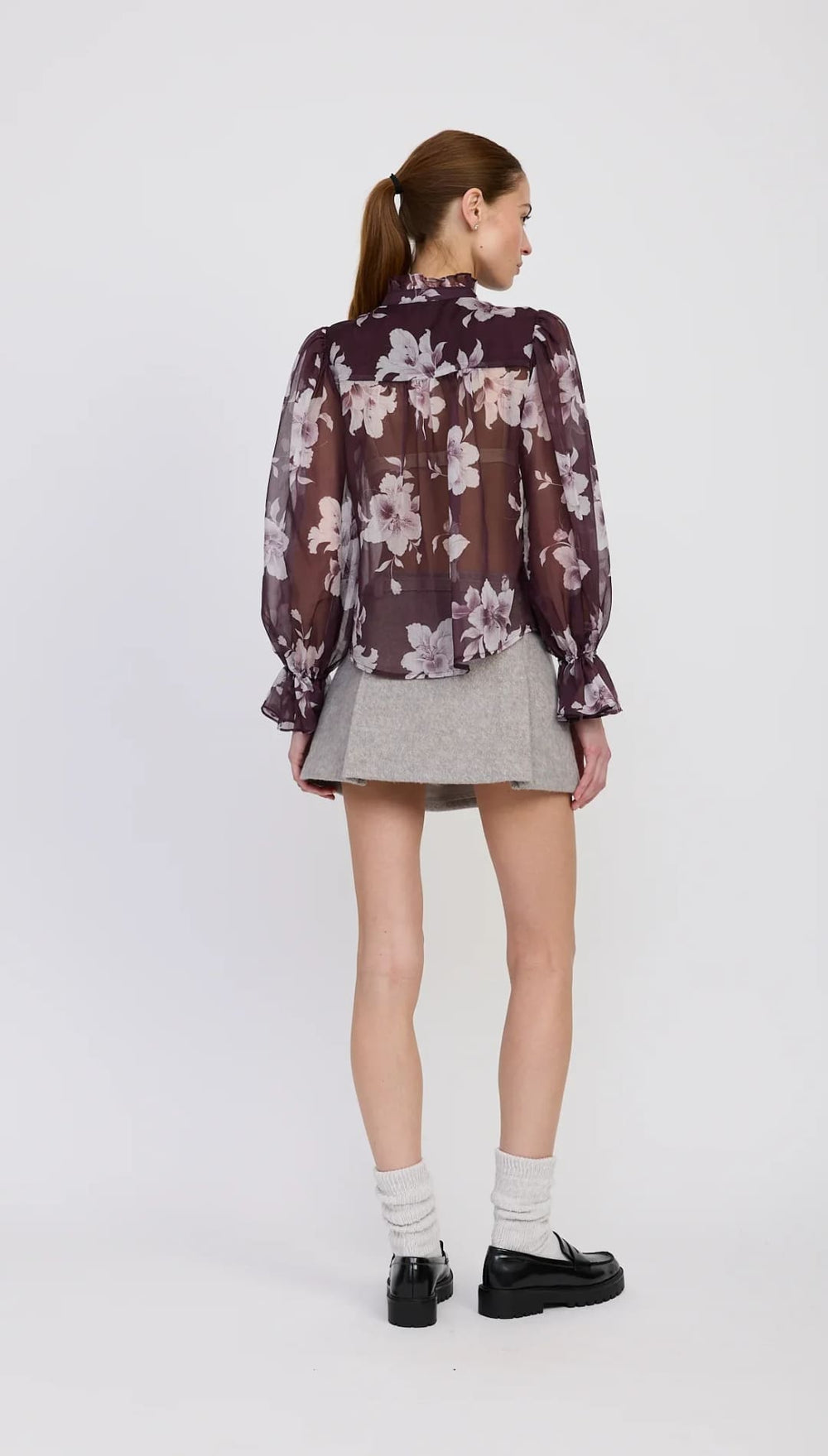 A sheer floral print blouse in shades of purple and cream.