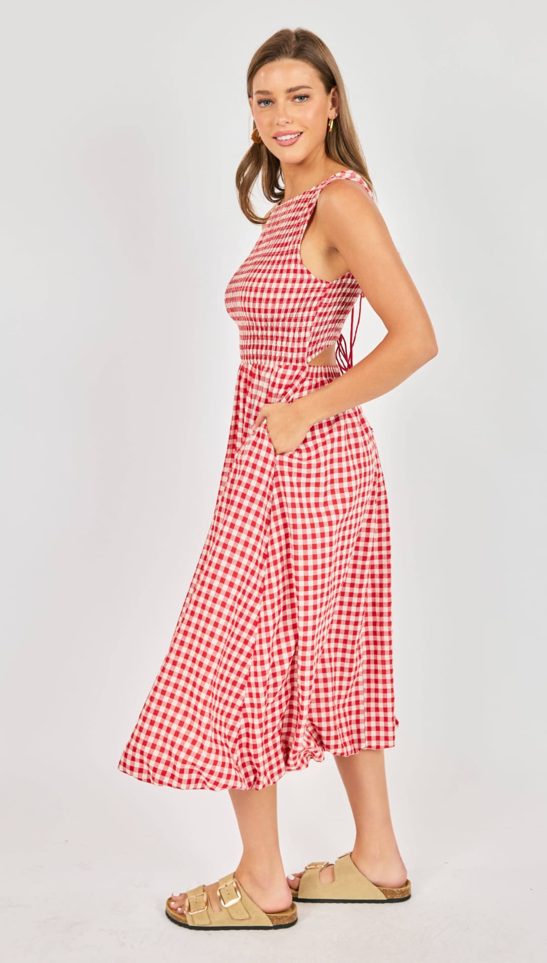 A red and white gingham midi dress with a halter neckline, side cutouts, and a flared skirt.