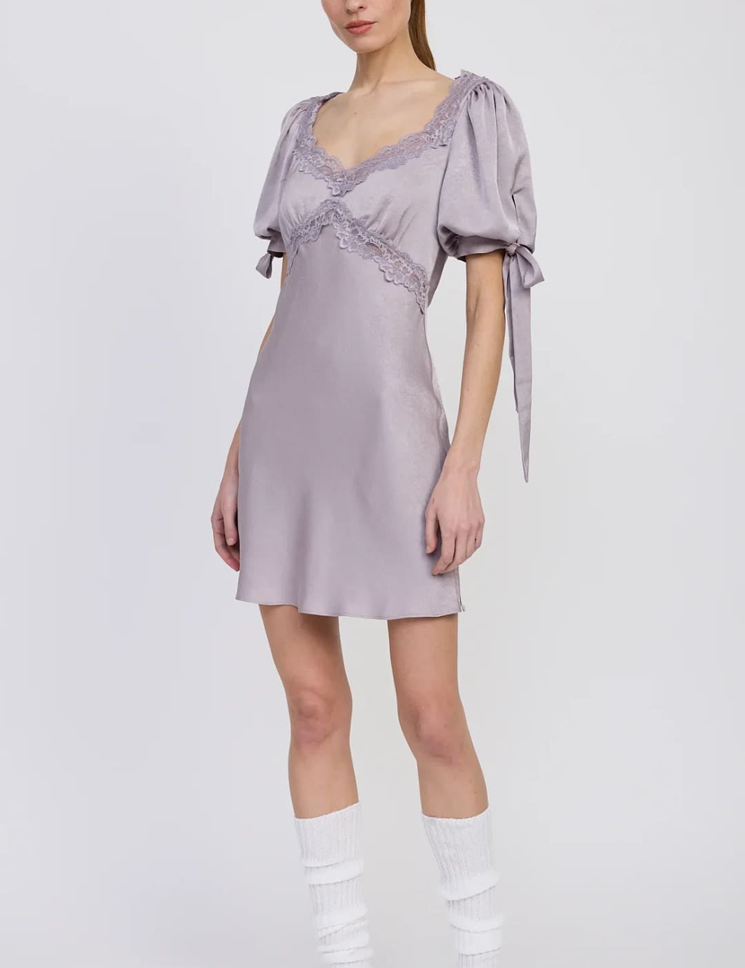 A lavender-colored satin mini dress with puff sleeves, lace trim, and tie details.