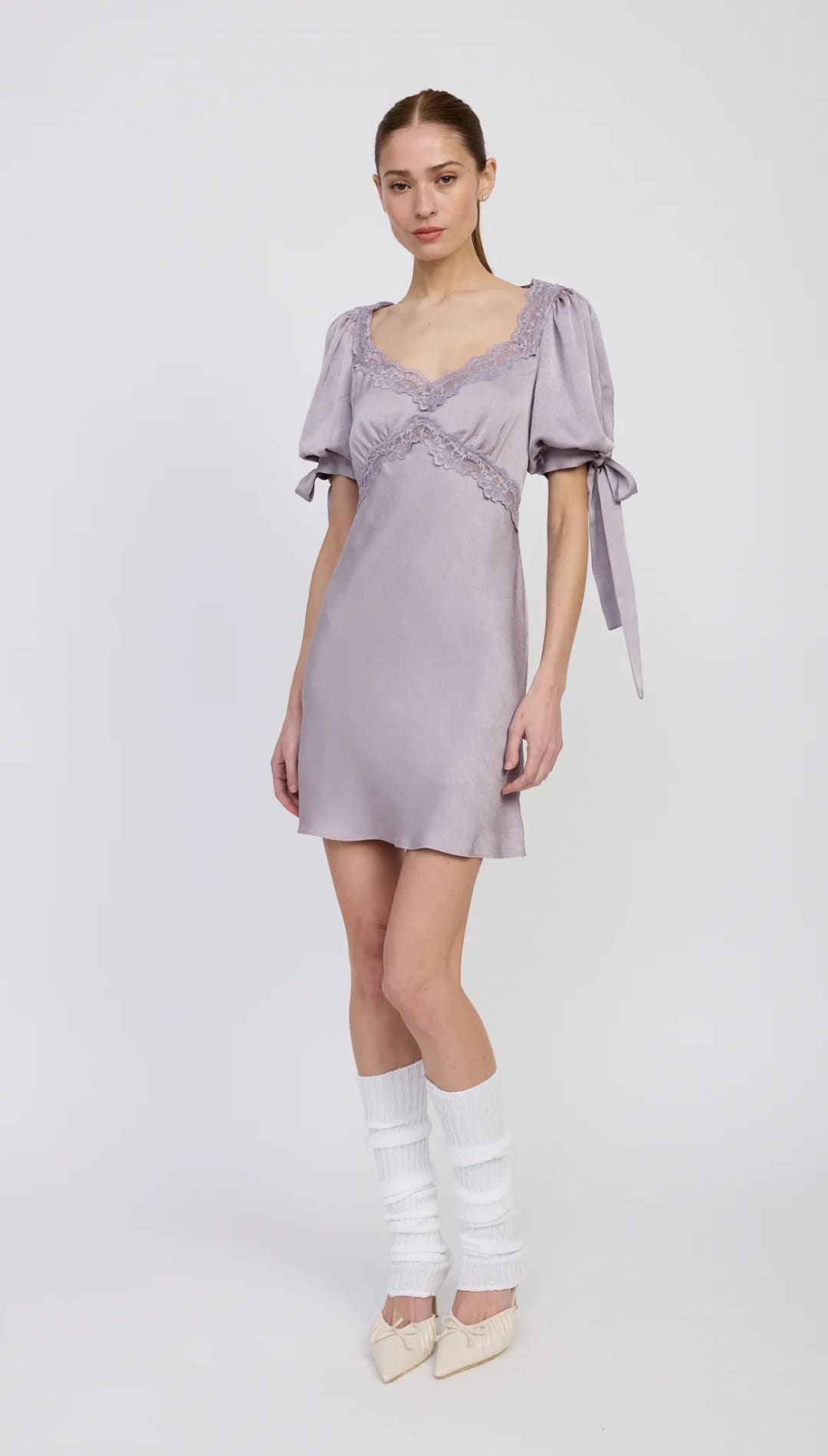 Lavender satin mini dress with puff sleeves, lace trim, and ribbon ties.