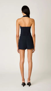 Navy blue halter-neck romper with a fitted bodice and flared shorts