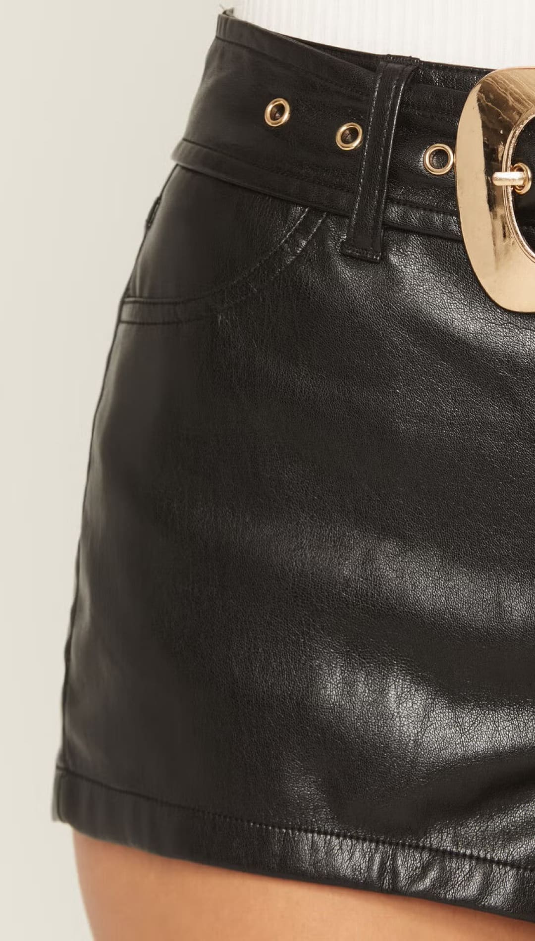 Black leather mini skirt with gold buckle belt detail.