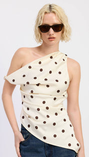 Cream-colored one-shoulder top with black polka dots and a ruched, draped design.