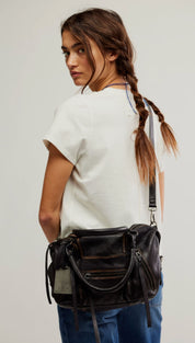 Black leather crossbody bag with multiple zippers and frayed straps.