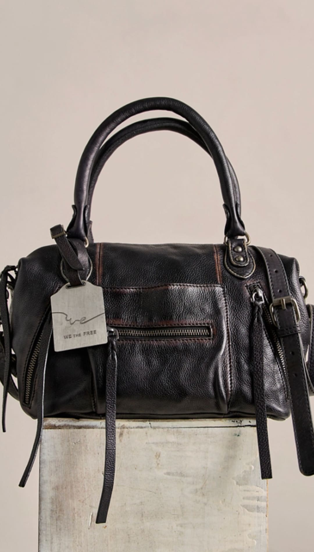 Black leather handbag with dual top handles and a detachable shoulder strap.