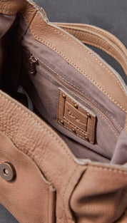 Tan leather crossbody bag with a textured surface and reinforced stitching.