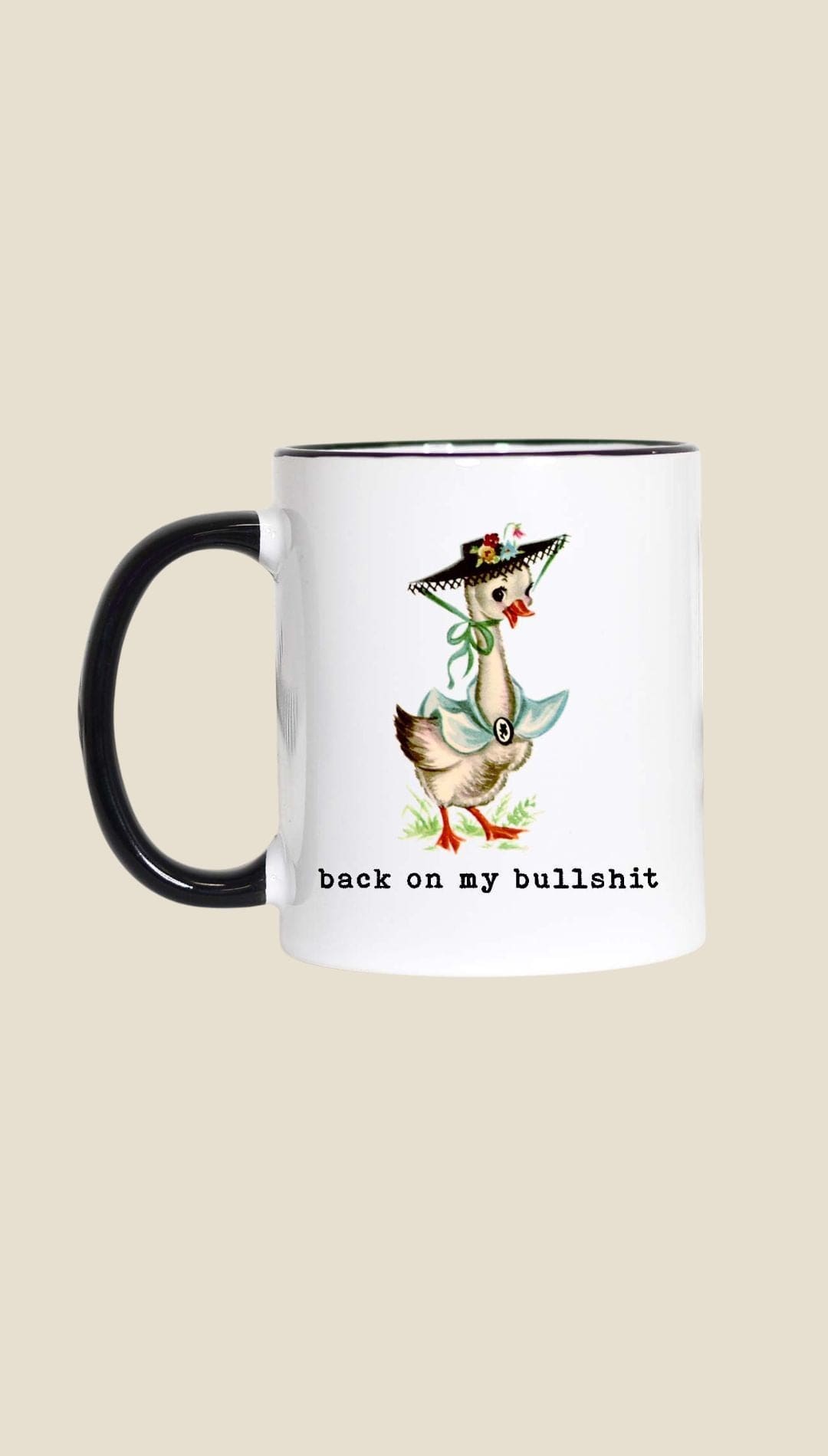 Ceramic coffee mug with black handle and rim, featuring a duck illustration in green dress and hat design.