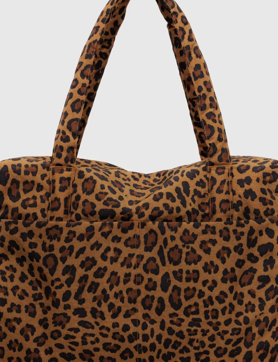 Leopard print tote bag with brown and black spots on a tan background, made of fabric.