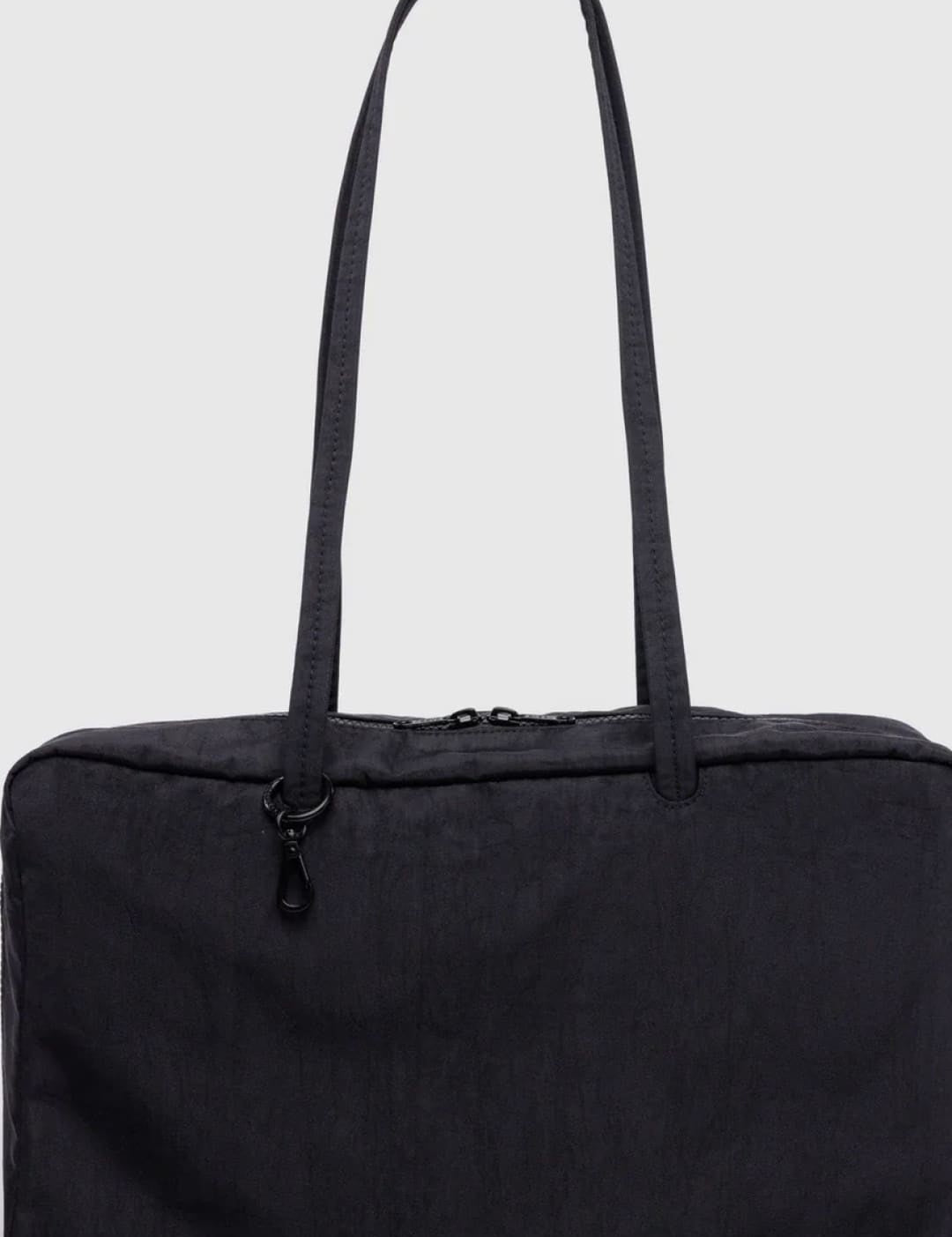 Black nylon tote bag with zipper closure and adjustable shoulder strap.