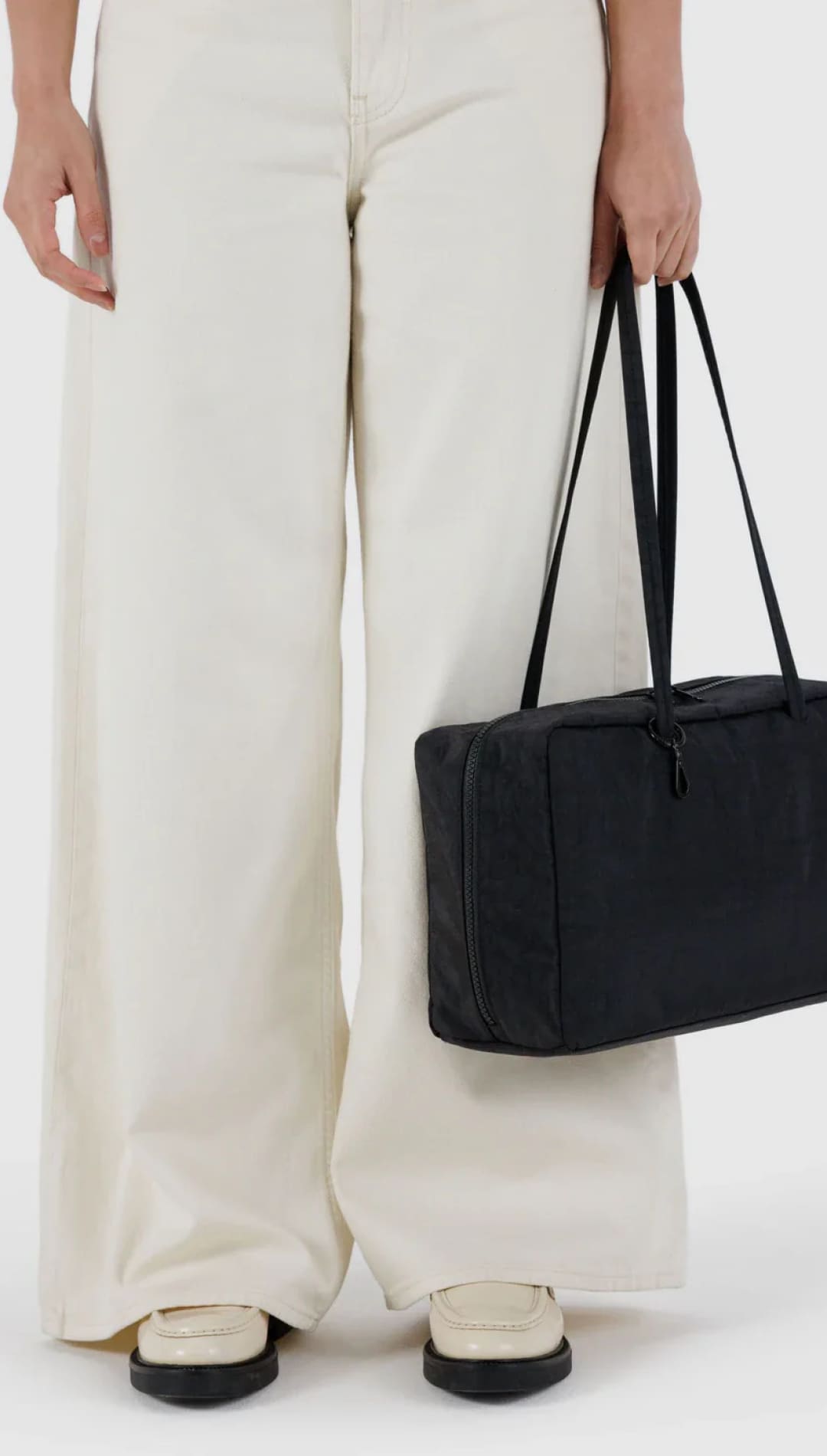 Black rectangular tote bag with long handles and structured design.