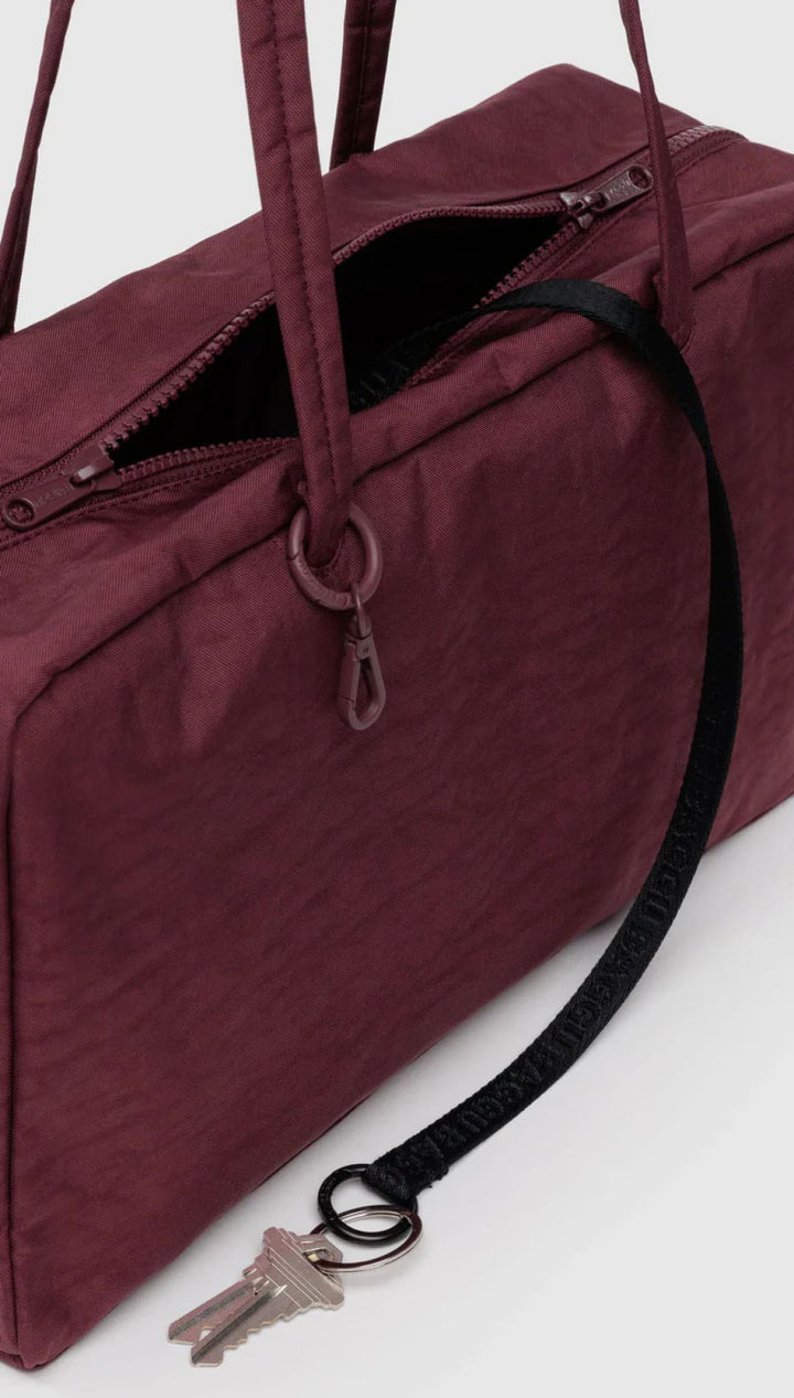 Burgundy nylon tote bag with black strap and keychain loop, ugg brand.