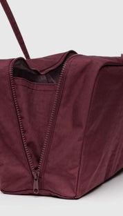 Burgundy tote bag with zipper closure and adjustable straps.