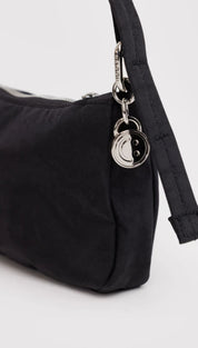 Black nylon shoulder bag with silver hardware and yin-yang charm.