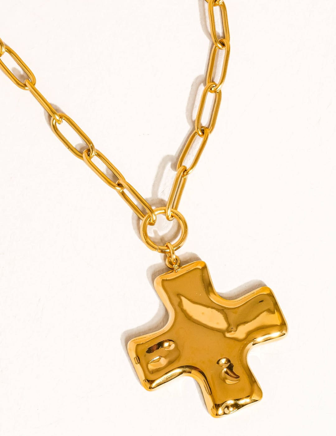 Gold-toned cross pendant necklace with a chunky, textured chain.