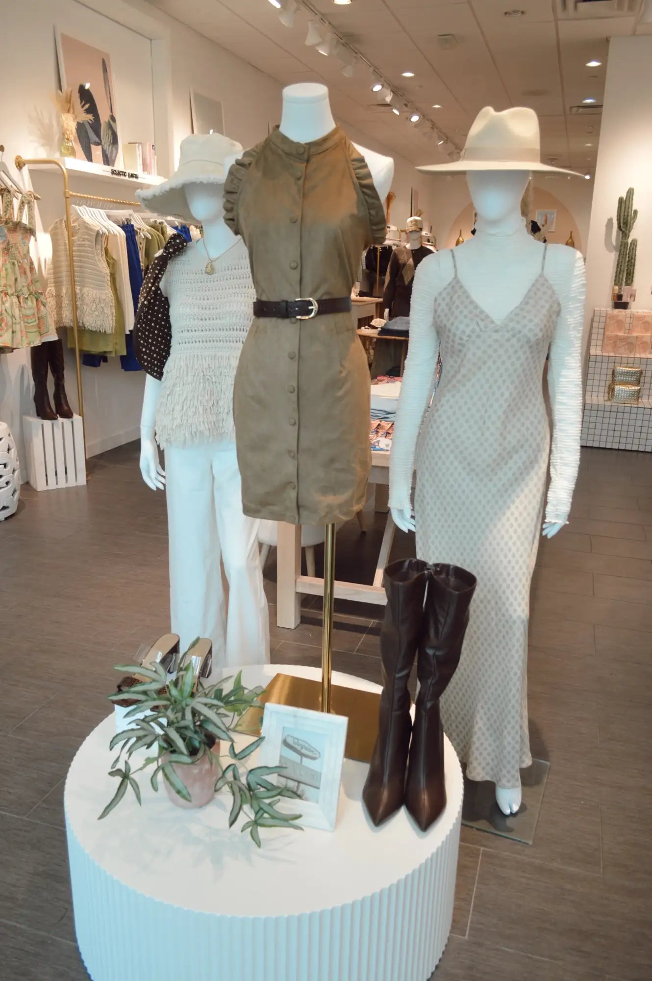A beige, button-front dress with ruffled sleeves and a black belt.
