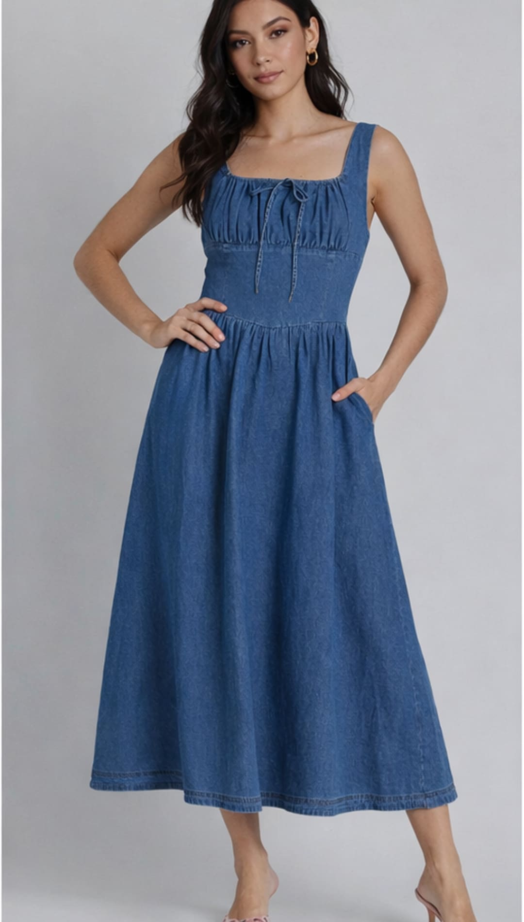 A blue denim midi dress with a square neckline, gathered bodice and front tie detail.