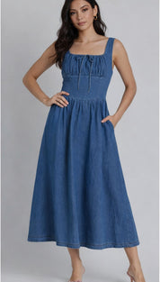 A blue denim midi dress with a square neckline, gathered bodice and front tie detail.