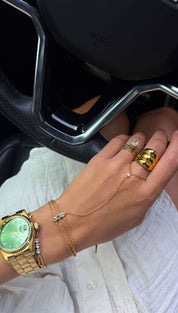 Gold-tone wristwatch with a vibrant green dial and classic hour markers, featuring a polished metal bracelet.