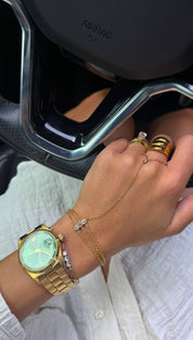 Gold-toned wristwatch with a mint green dial and diamond accents on the bezel, featuring a classic stainless steel bracelet design.