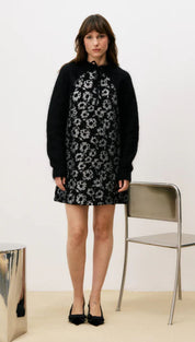 Black floral dress with white accents, textured fabric, and a high neckline.