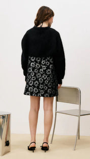 Black floral print mini skirt with high waist and button closure.