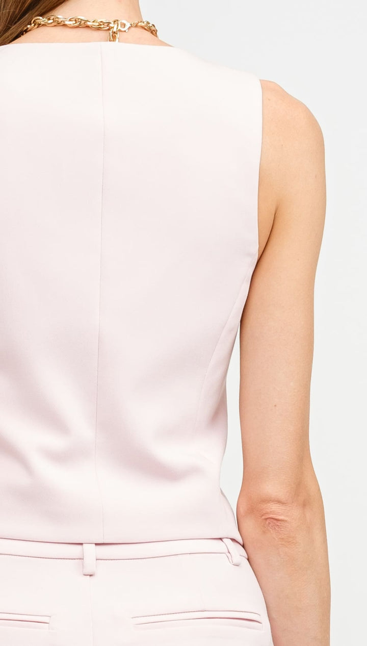 Sleeveless pink blouse shown from behind.