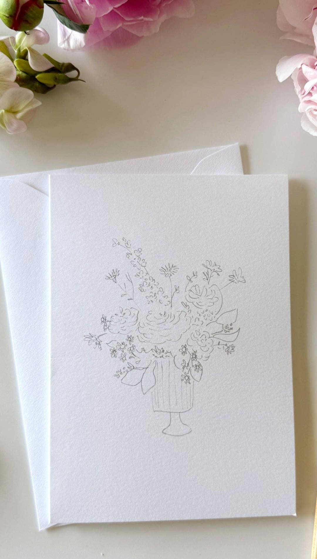 White greeting card with floral design and envelope set.