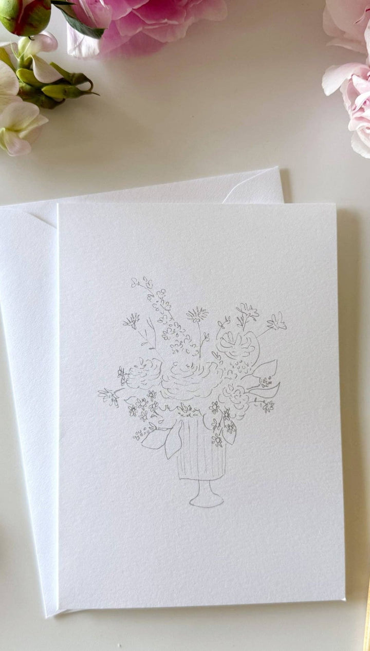 White greeting card with floral design and envelope set.