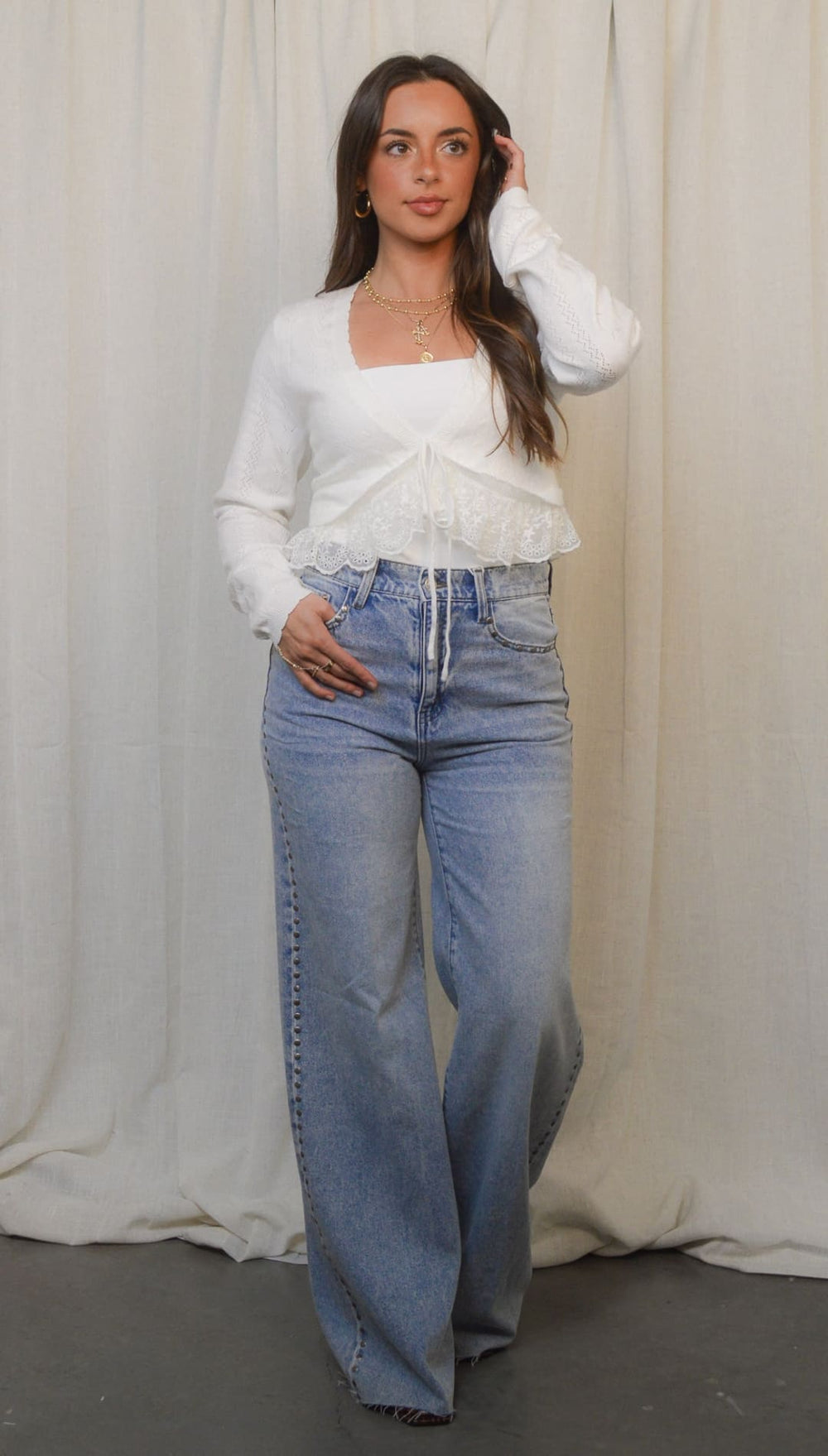 Woman in wide-leg jeans and white top.