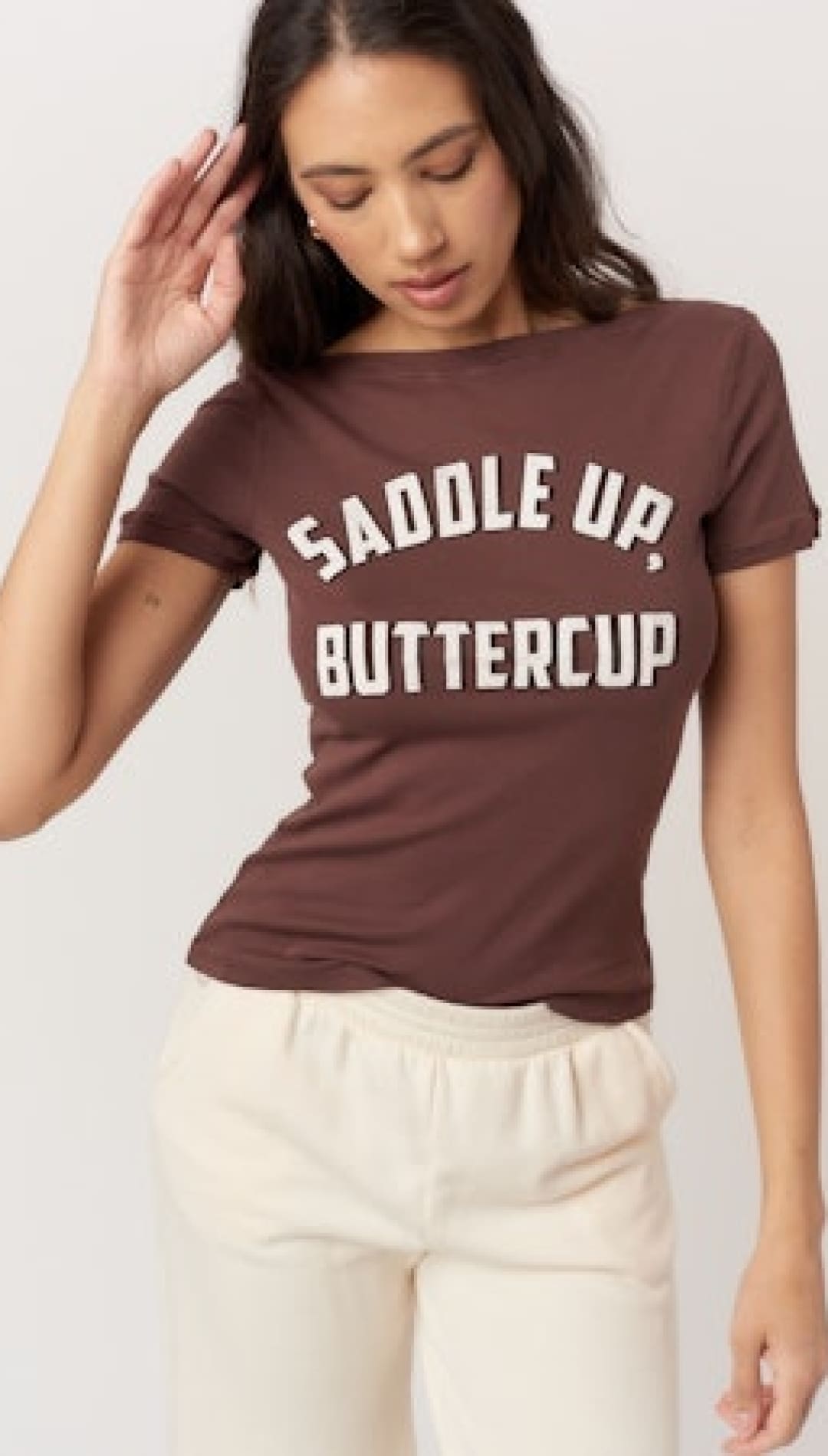 A short-sleeved, brown t-shirt with ’SADDLE UP, BUTTERCUP’ printed in white on the front.