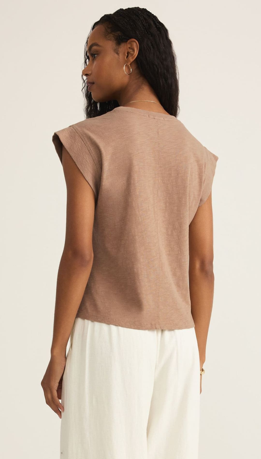 Woman in a brown sleeveless top.