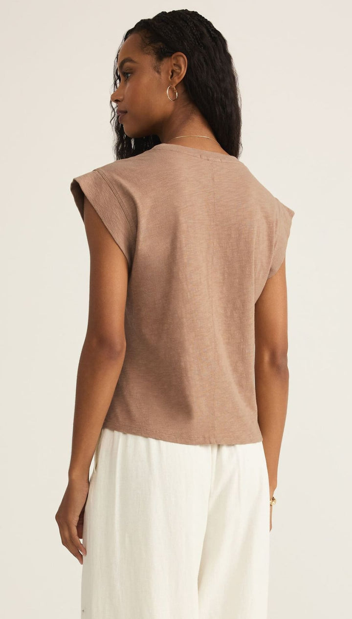 Woman in a brown sleeveless top.