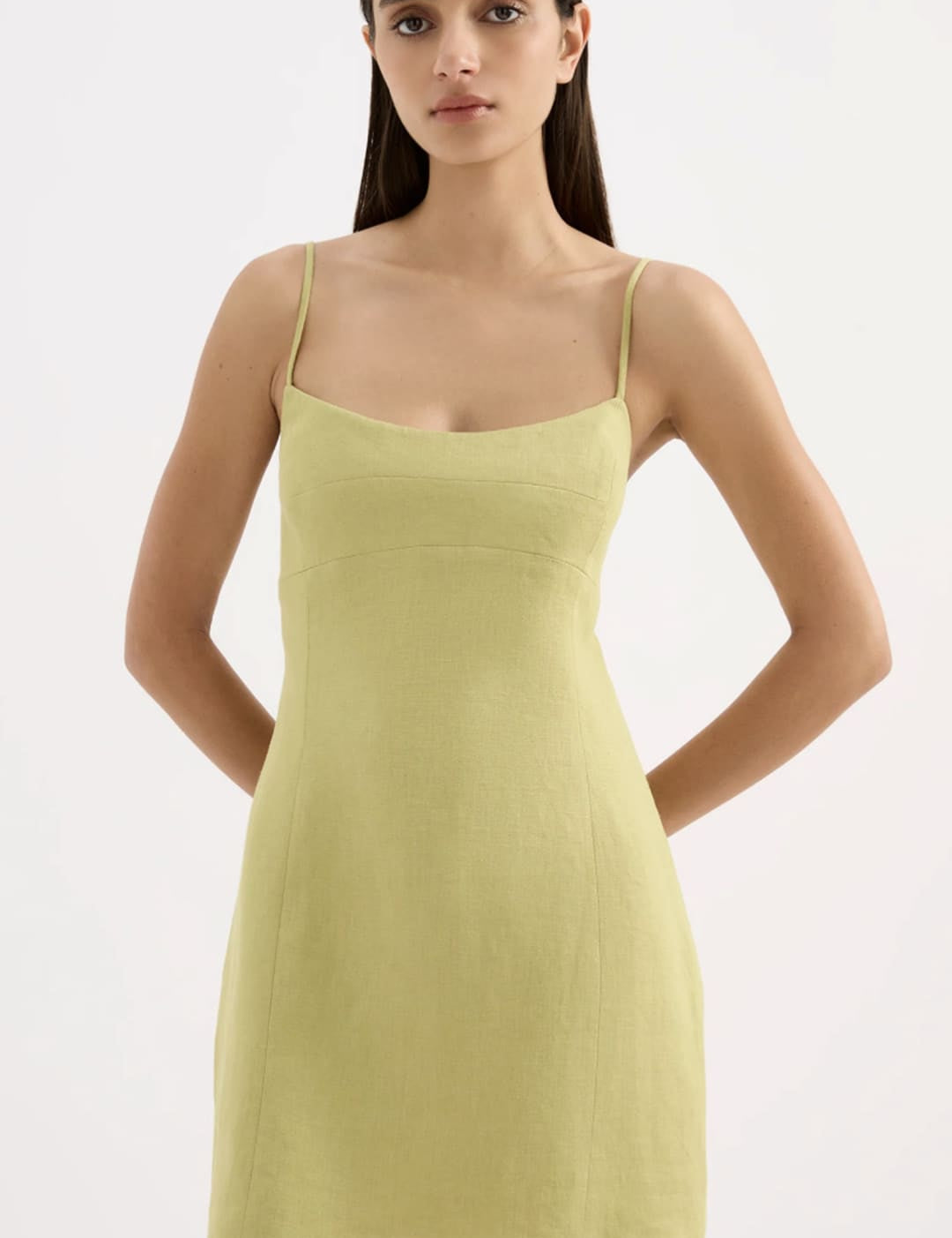 A sleek, pale green sleeveless mini dress with thin spaghetti straps and a flattering fitted silhouette.