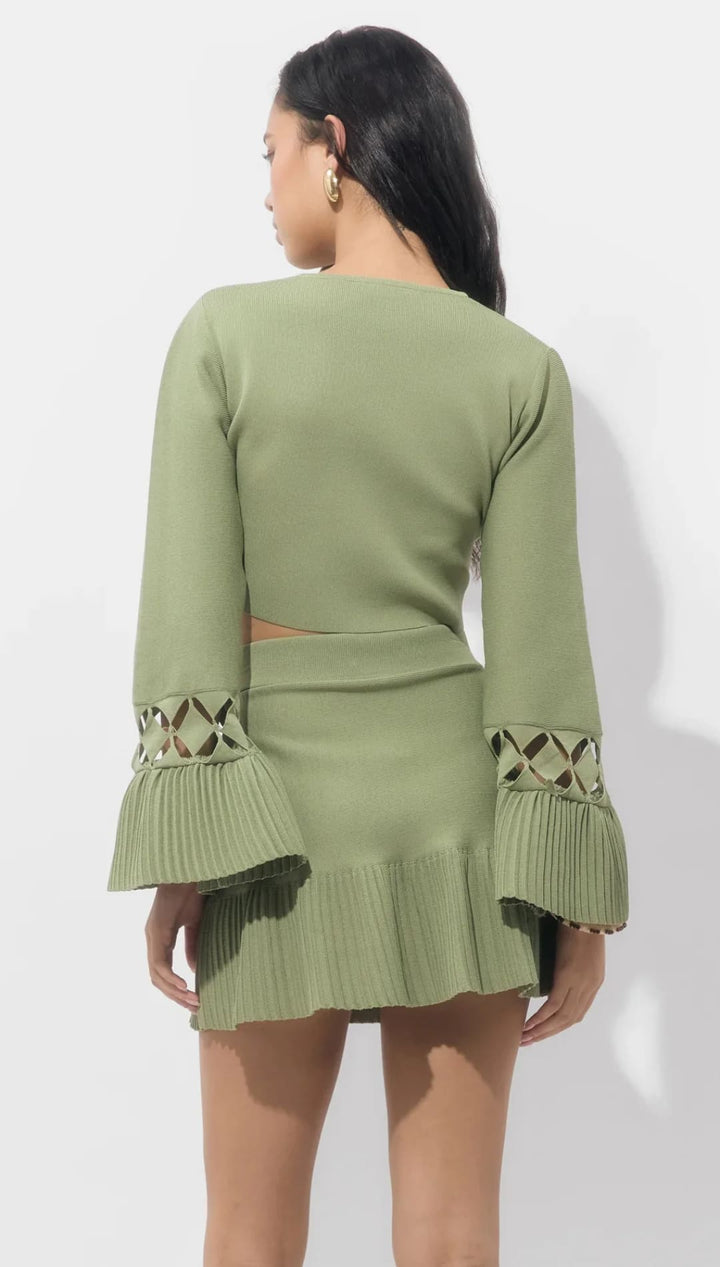 Olive green knit dress with bell sleeves and geometric cutouts, inspired by zara’s spring collection.