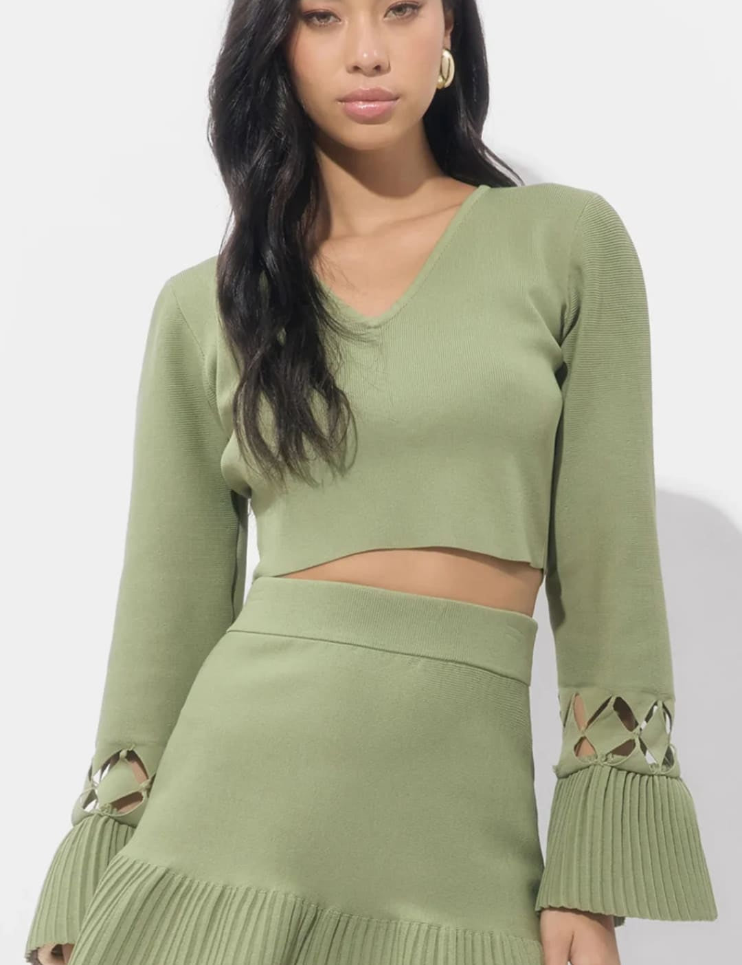 Olive green ribbed knit two-piece set with bell sleeves and ruffled hem, featuring a crop top and mini skirt.