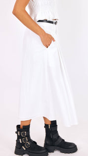 White pleated midi dress with a smocked bodice and black belt.