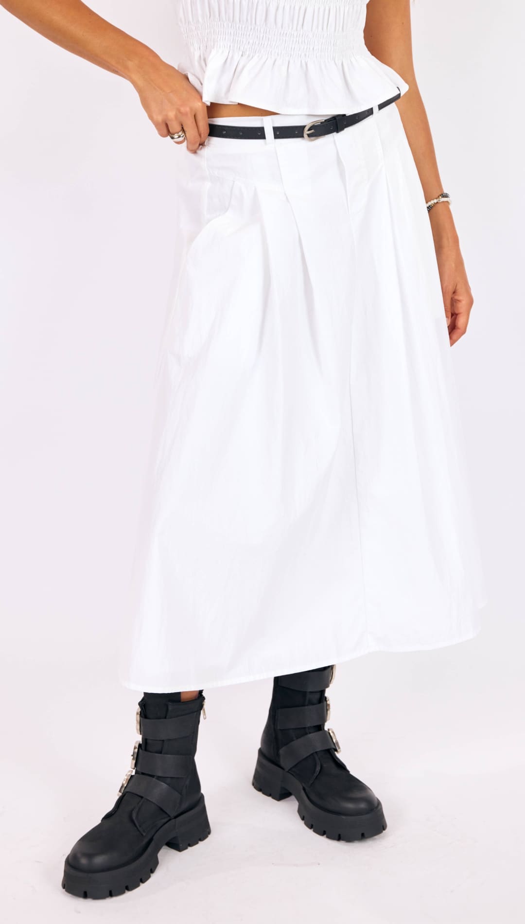 White pleated midi skirt with a smocked waistband and black belt.