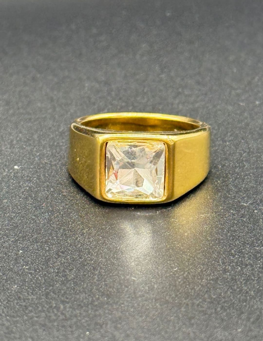 Gold ring with square gemstone.