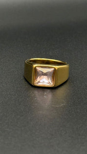 Gold ring with square pink gemstone.