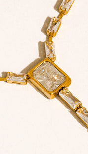Gold-toned chain necklace featuring rectangular, faceted clear crystals set in a bold geometric design.