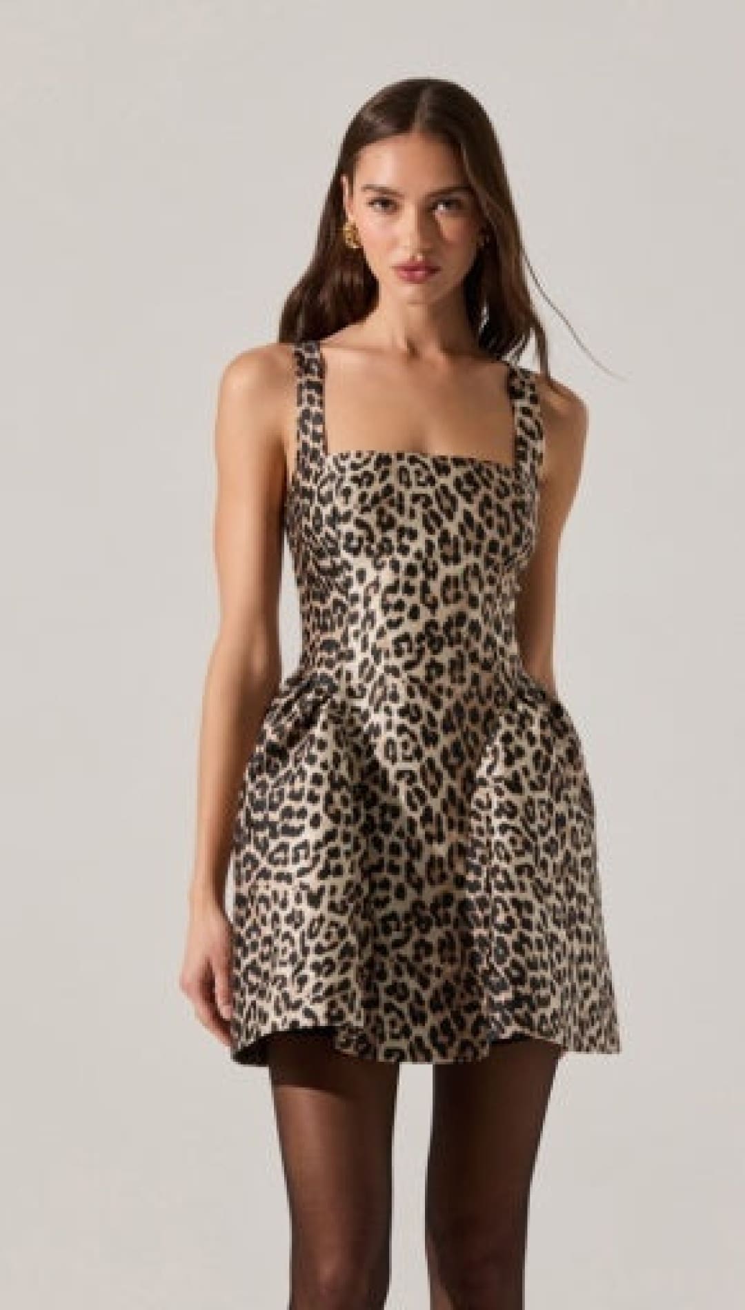 A sleeveless leopard print mini dress with a square neckline and a flared skirt with pockets.