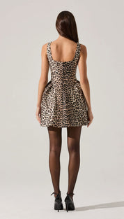 Leopard print sleeveless mini dress with black sheer tights and heels.