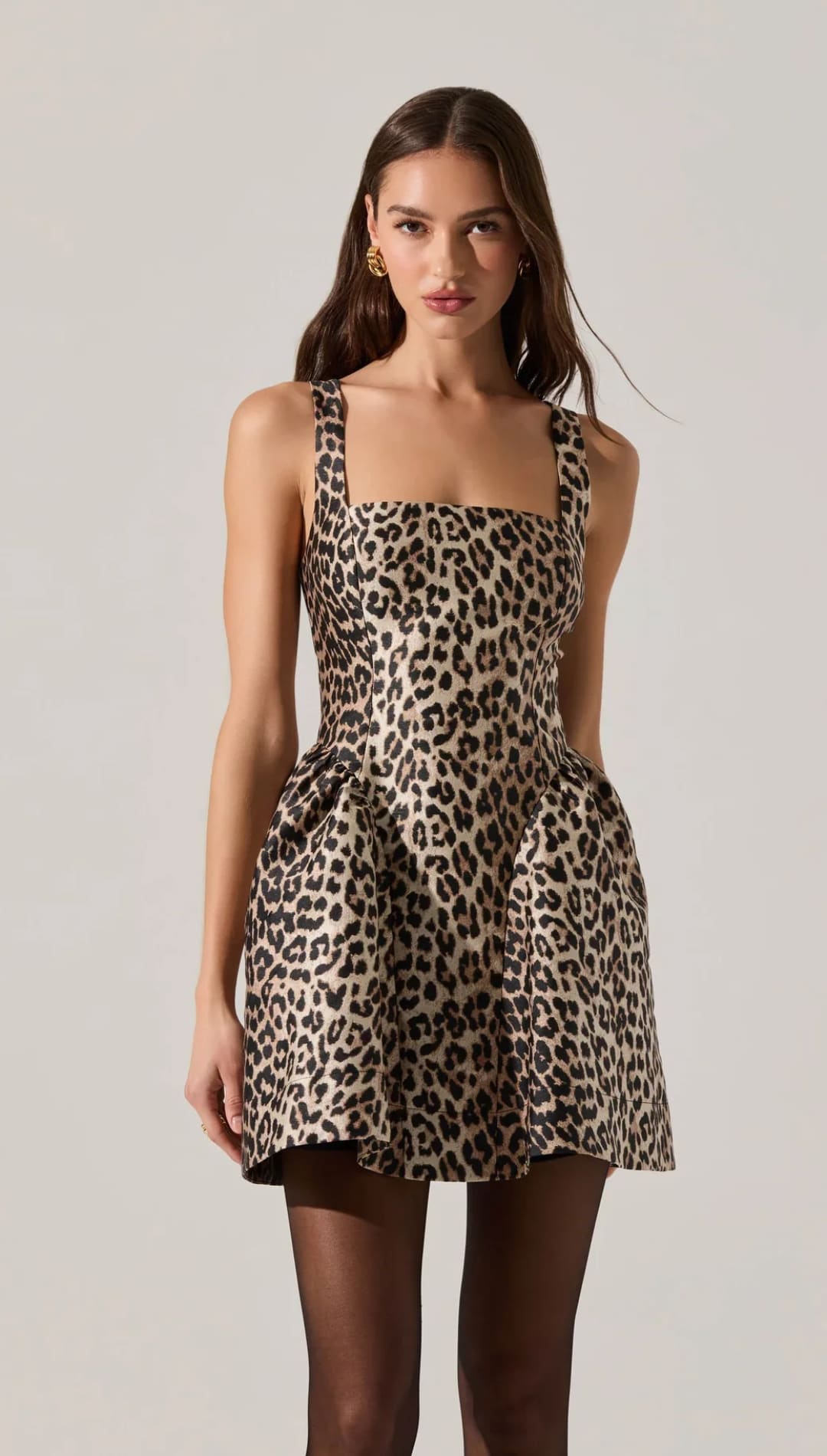 A sleeveless, leopard print mini dress with a square neckline and a full skirt with pockets.