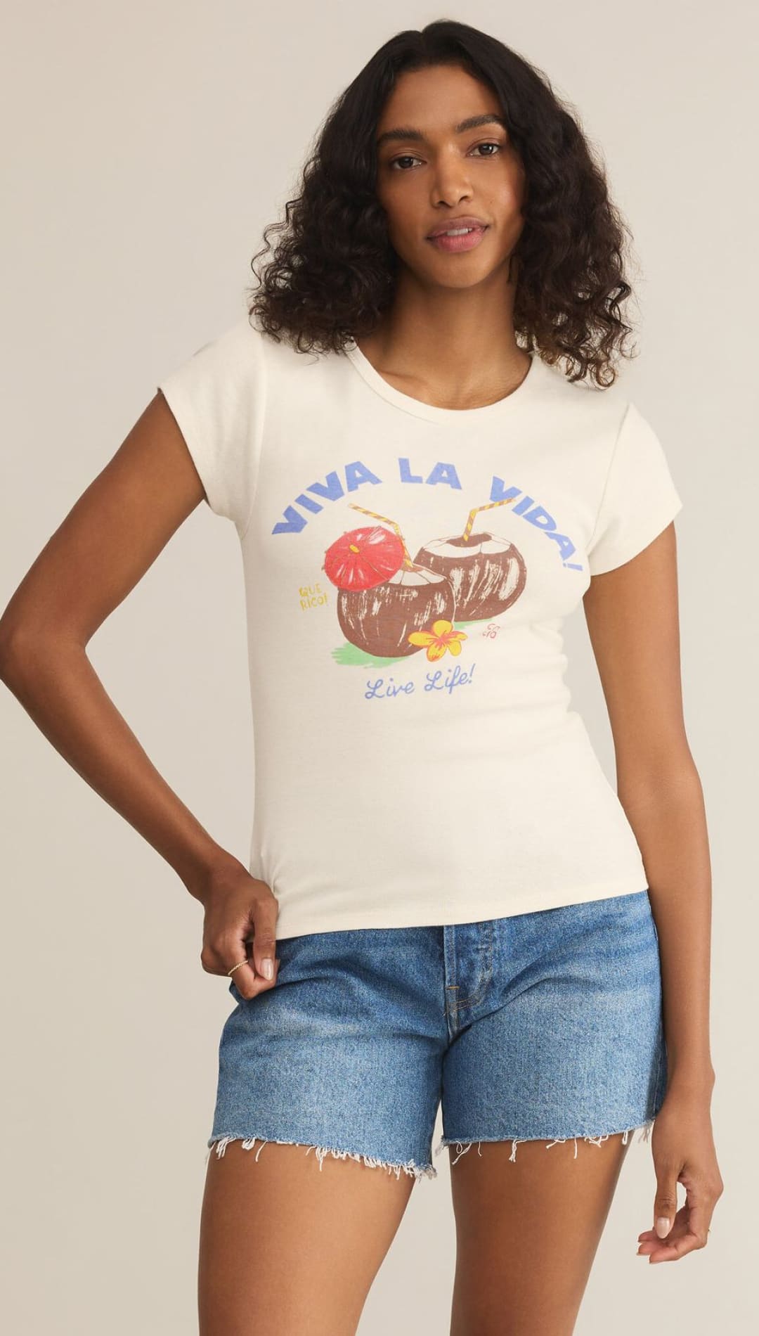 Woman wearing a graphic tee and denim shorts.