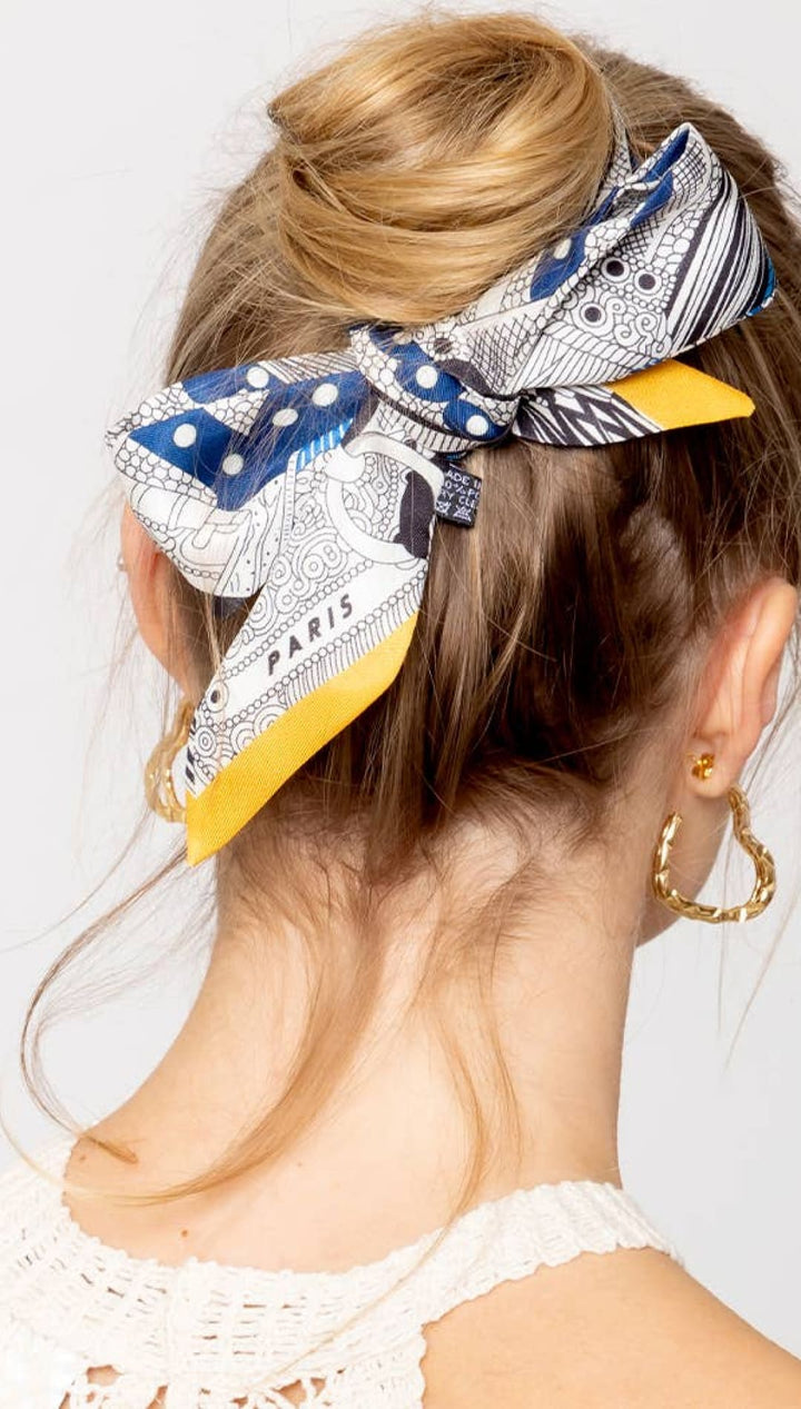 Blonde hair bun with patterned scarf.