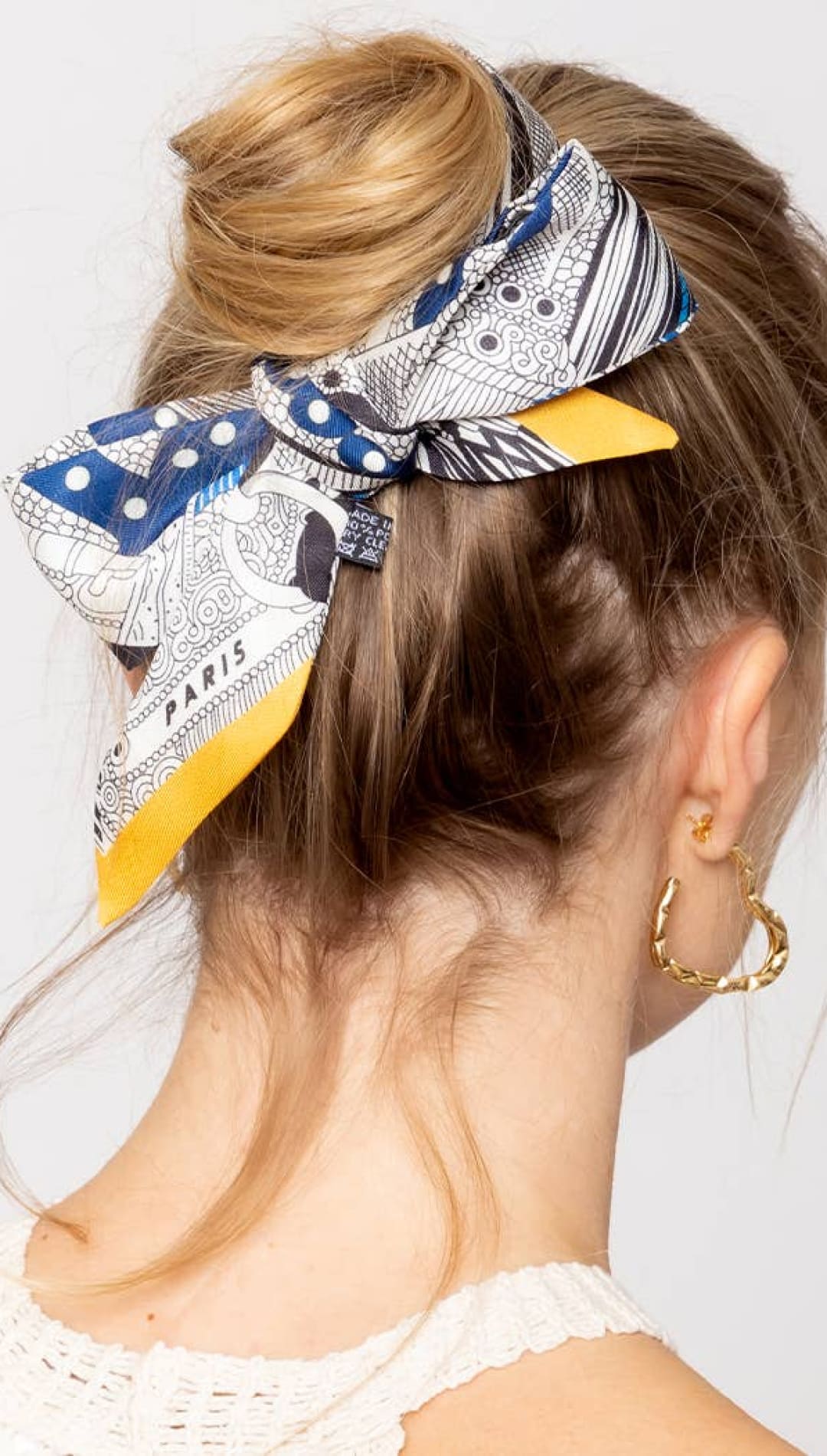 Blonde hair bun with patterned scarf.