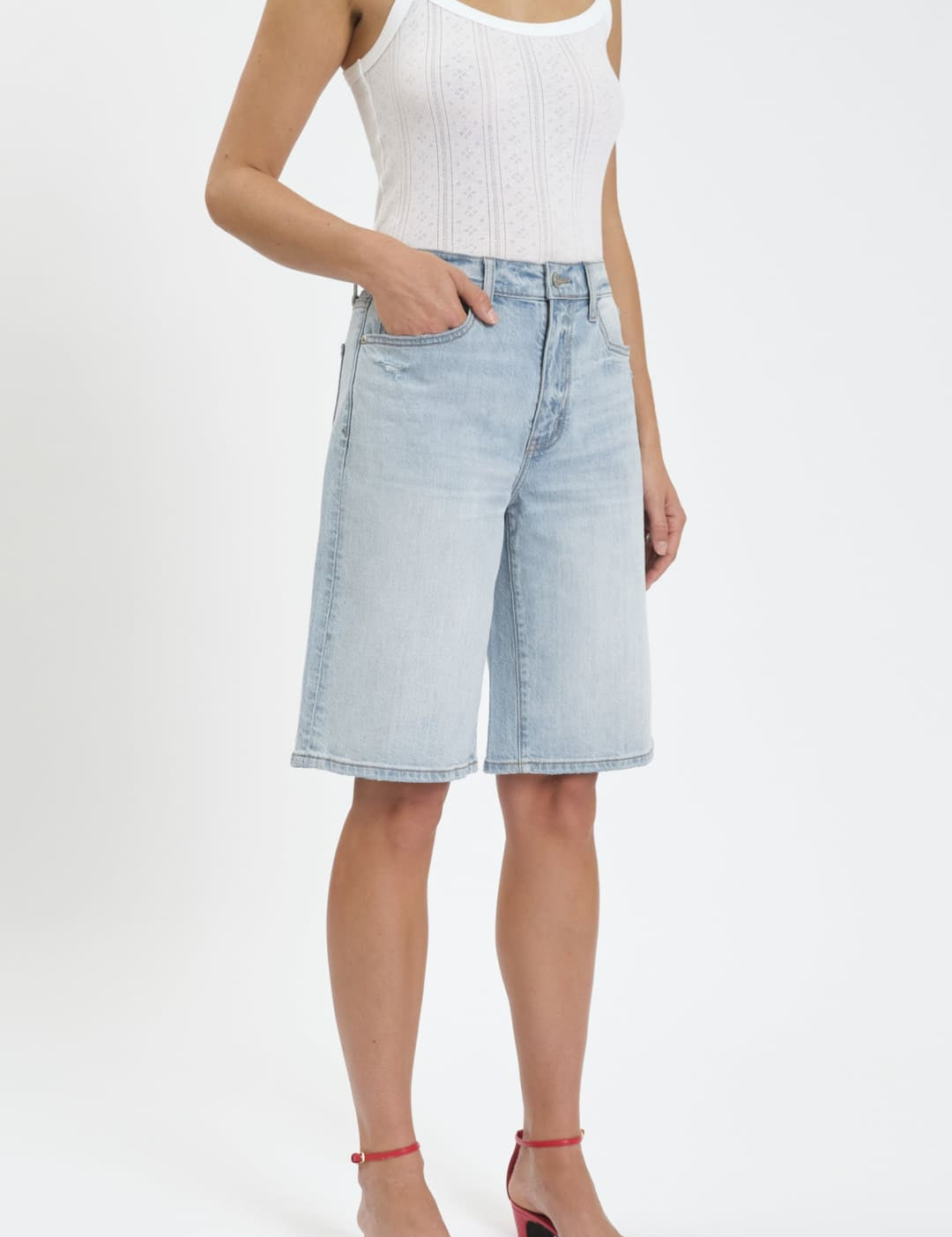 Woman’s white tank top and denim shorts.