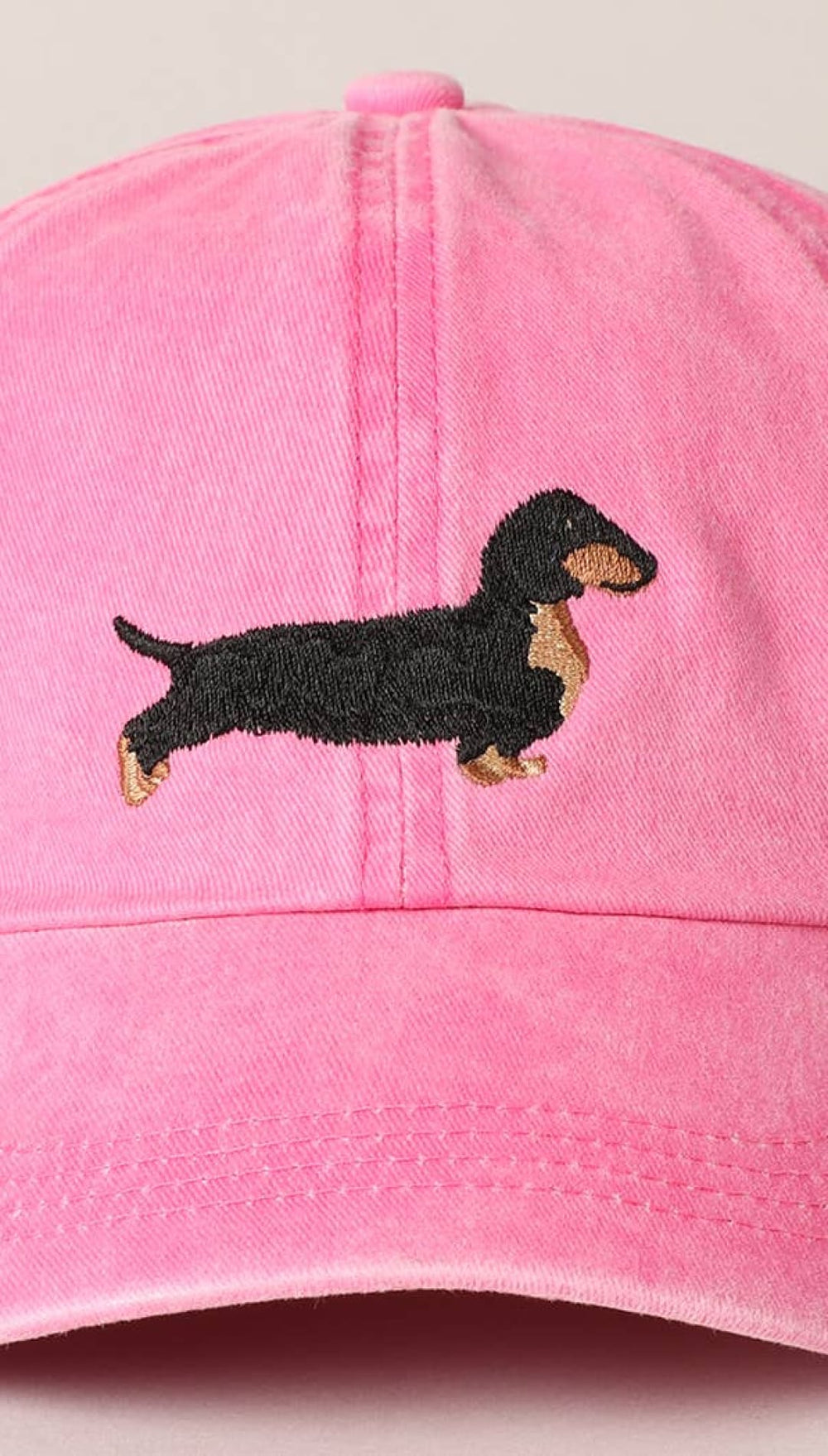 Pink baseball cap with dachshund embroidery.